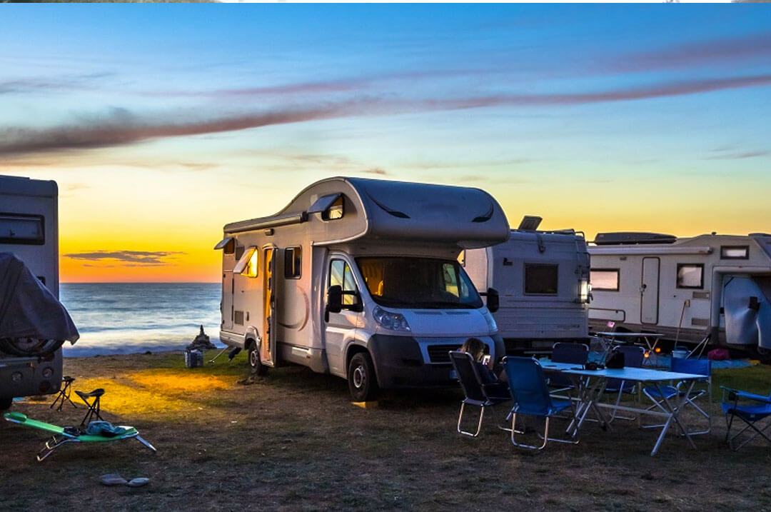 Motorhomes ao pôr do sol na praia - liberdade de ir e vir